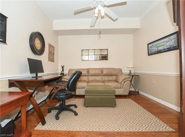 Office area with wood finished floors, ornamental molding, baseboards, and ceiling fan