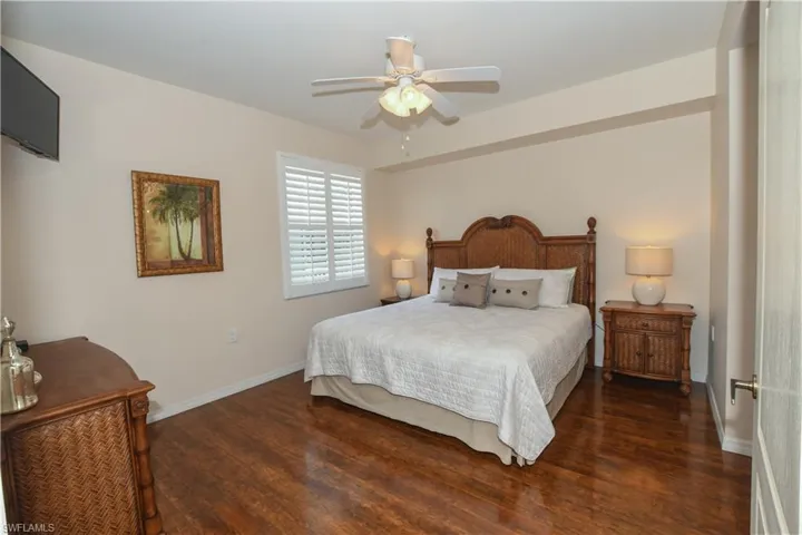 Bedroom featuring baseboards, wood finished floors, and ceiling fan