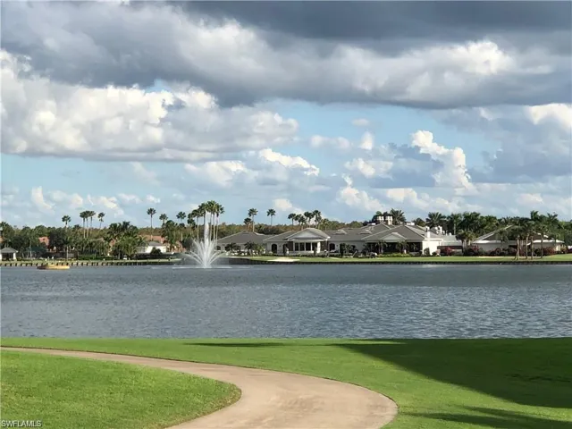View of property's community featuring a lawn and a water view