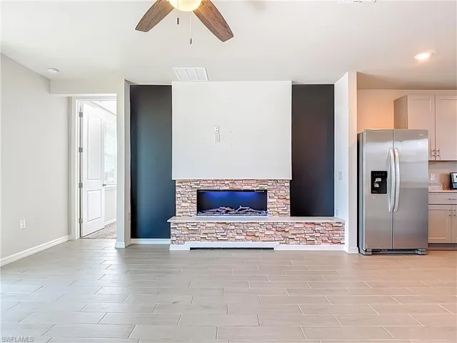 Unfurnished living room with ceiling fan and wood finish floors