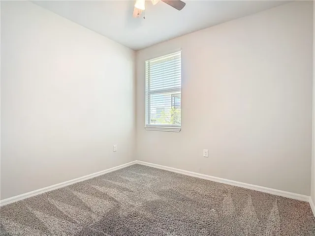 Unfurnished room featuring carpet floors and ceiling fan