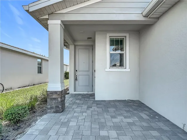 View of exterior entry featuring a porch and stucco siding