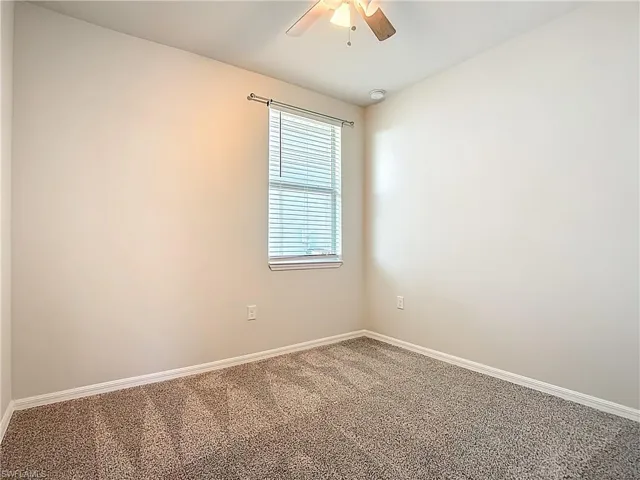Empty room with carpet floors and a ceiling fan