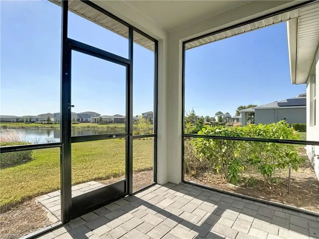 Unfurnished sunroom with a water view and a residential view
