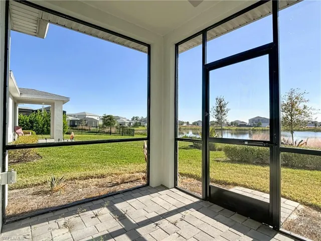 Unfurnished sunroom featuring a water view and a residential view