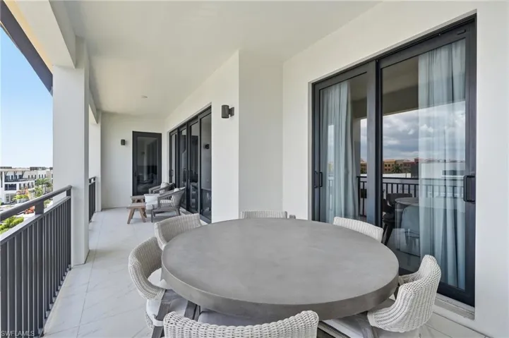 Expansive balcony featuring black metal railings and tiled flooring