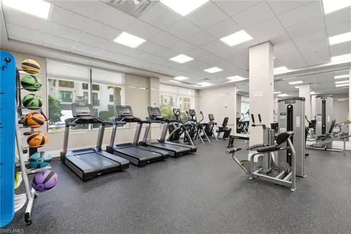 Fitness center featuring multiple treadmills, exercise bikes, and strength training equipment