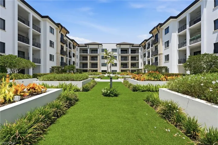 Courtyard garden with manicured lawn, raised planters, and mature landscaping