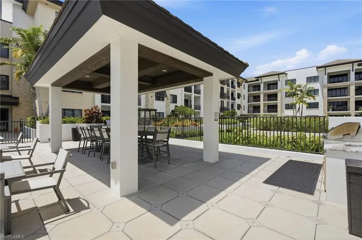 Covered outdoor entertaining area featuring a wood-finish ceiling, paver patio, and built-in grill
