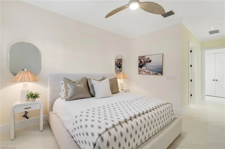Bedroom with ornamental molding, ceiling fan, and light tile patterned floors