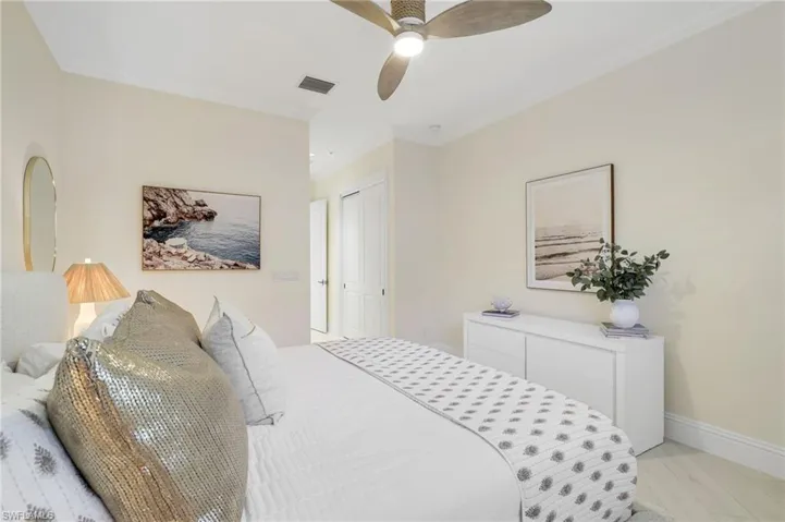 Bedroom with crown molding, a ceiling fan, and light wood-style flooring