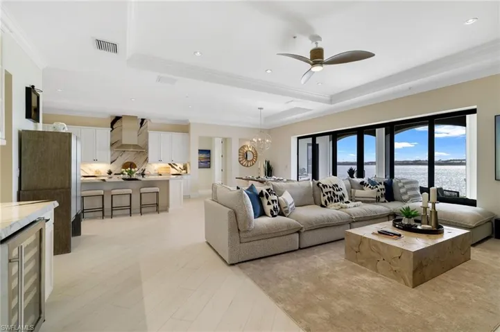 Living area featuring beverage cooler, a chandelier, ornamental molding, a ceiling fan, and recessed lighting