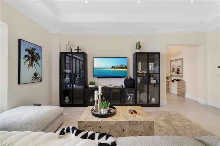 Living room with crown molding and a raised ceiling