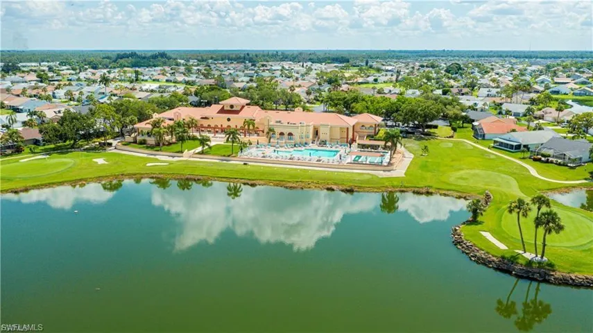 Expansive body of water, golf course frontage, multiple swimming pools, and a substantial clubhouse structure