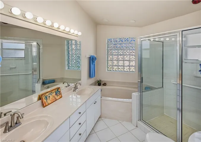 Dual vanity with undermount sinks, large mirror, and overhead strip lighting
