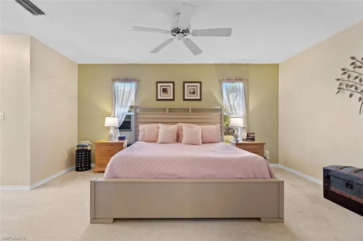 Bedroom with light carpet, baseboards, and visible vents