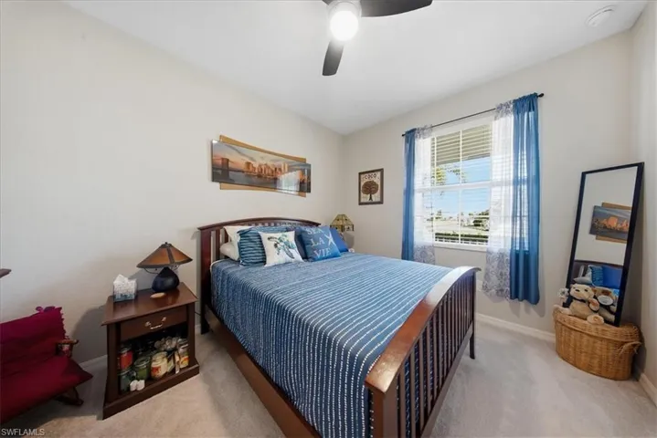 Carpeted bedroom with baseboards and ceiling fan