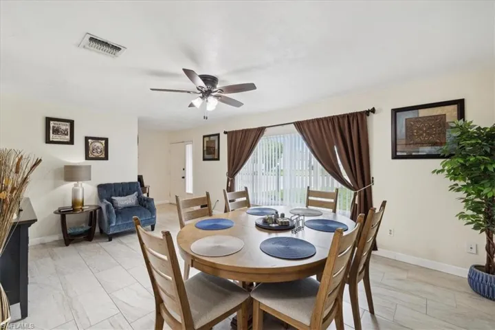 Dining space with light tile patterned flooring and ceiling fan
