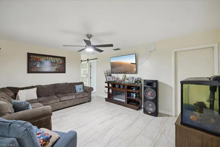 Living room with ceiling fan and a barn door