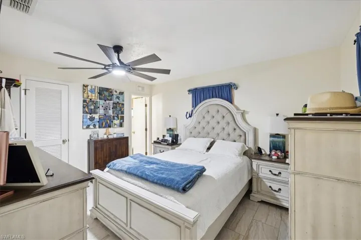 Bedroom with light hardwood / wood-style floors, a closet, and ceiling fan