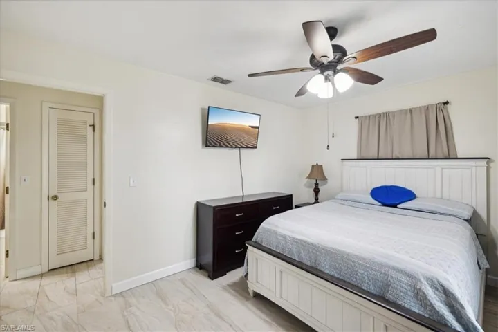 Tiled bedroom featuring ceiling fan