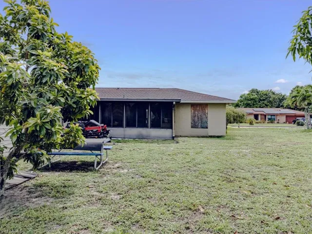 Back of property featuring a sunroom and a yard