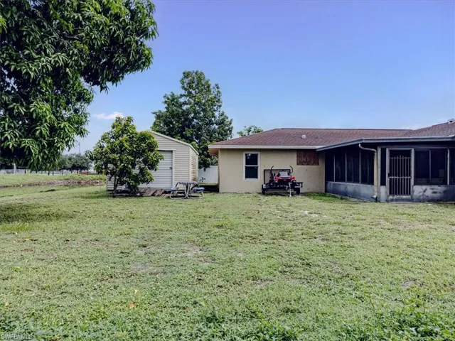 View of yard featuring a sunroom and a shed