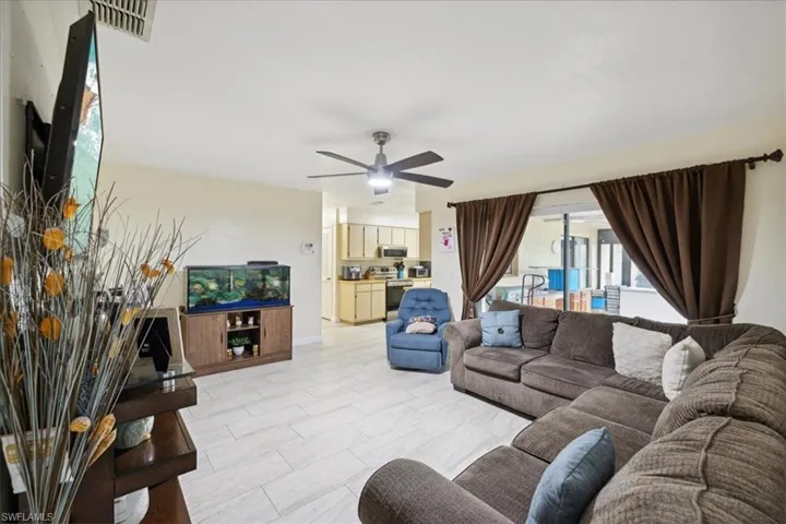 Living room with light tile patterned flooring and ceiling fan