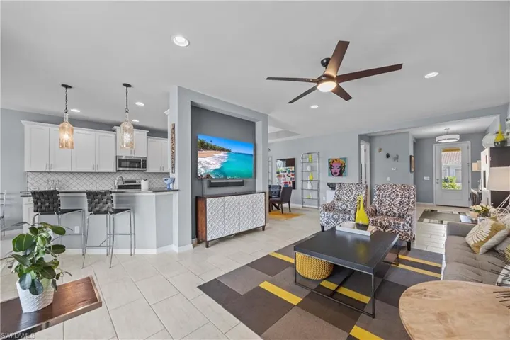 Great room with light tile patterned flooring and ceiling fan