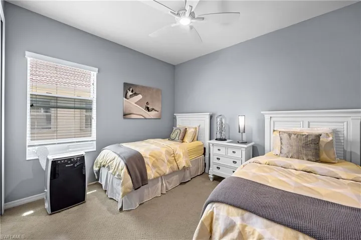 Carpeted bedroom featuring ceiling fan