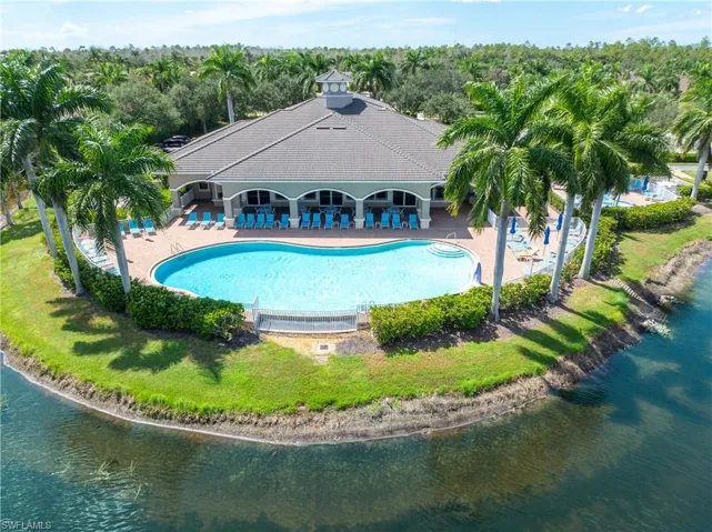 View of pool with a water view, a lawn, and lanai area