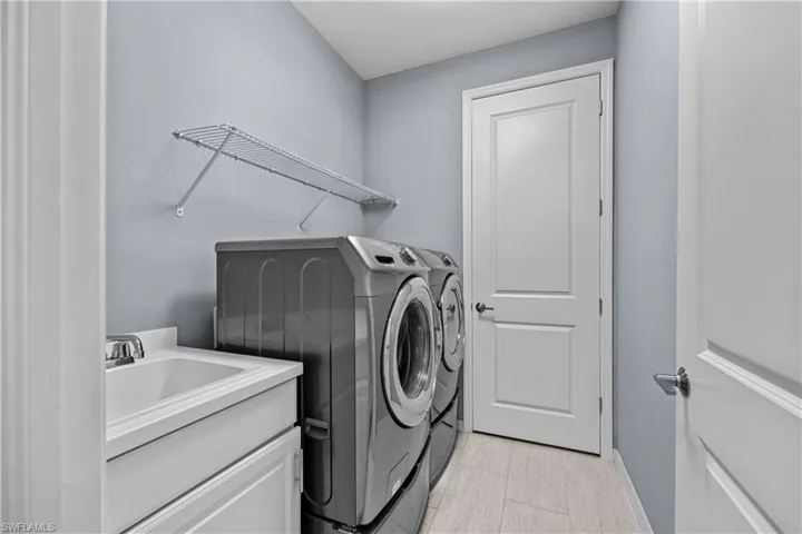 Washroom with sink and separate front loader washer and dryer