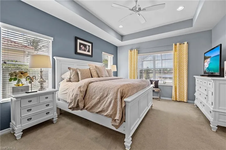 Carpeted bedroom featuring ceiling fan and a coffered ceiling