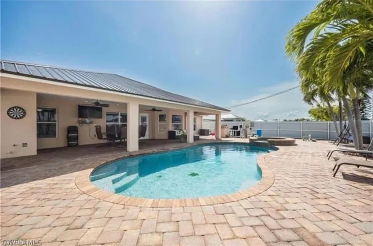 View of swimming pool with a patio, a fenced backyard, and a pool with connected hot tub