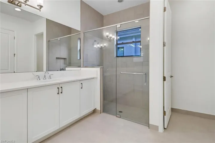 Bathroom featuring vanity and a shower with door