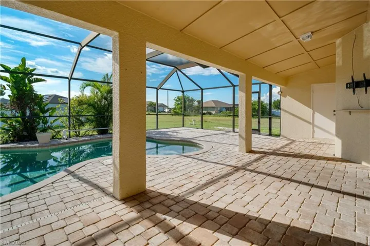 View of swimming pool featuring screen enclosure and a patio area