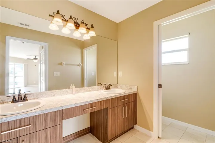 Bathroom with tile patterned flooring, ceiling fan, and vanity