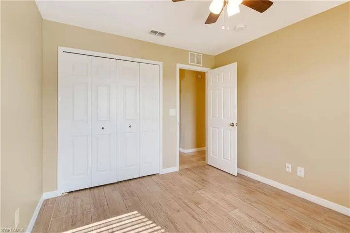 Unfurnished bedroom featuring a closet, light wood-type flooring, and ceiling fan