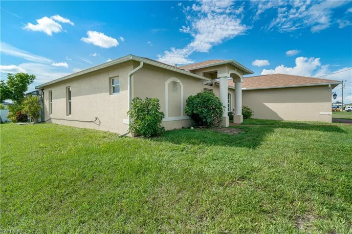 View of side of property featuring a lawn