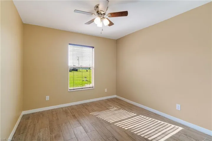 Empty room with light hardwood / wood-style floors and ceiling fan