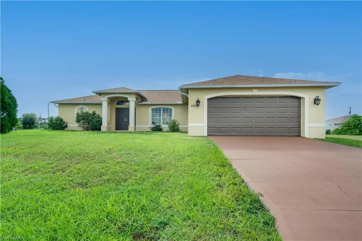 Ranch-style house with a front lawn and a garage