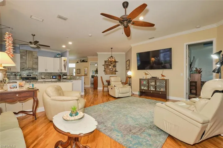 Living room with light hardwood / wood-style floors, sink, ornamental molding, and ceiling fan