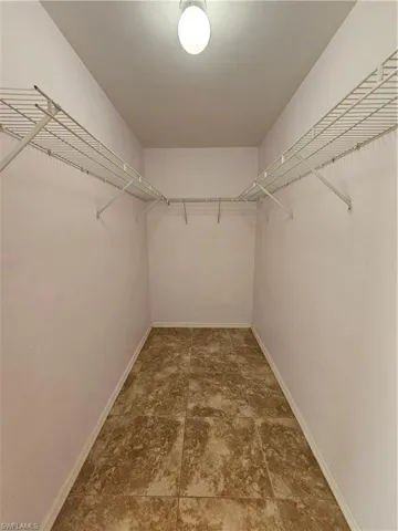Spacious walk-in closet featuring wire shelving and hanging rods