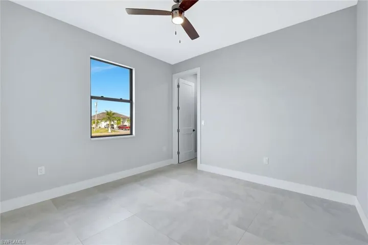 Unfurnished room with baseboards and a ceiling fan