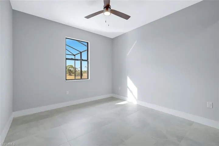 Spare room featuring baseboards and ceiling fan
