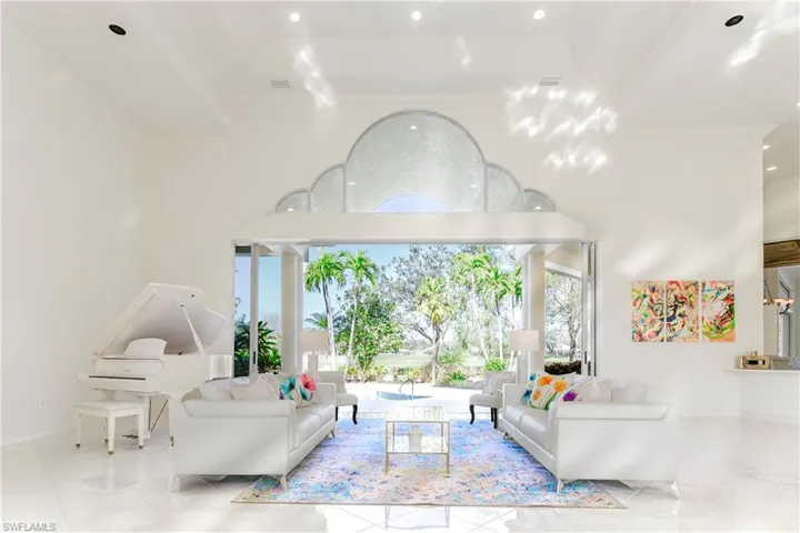 Living room with a high ceiling, a tray ceiling, and ornamental molding