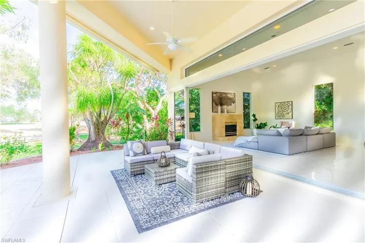 View of patio with ceiling fan and an outdoor living space with a fireplace