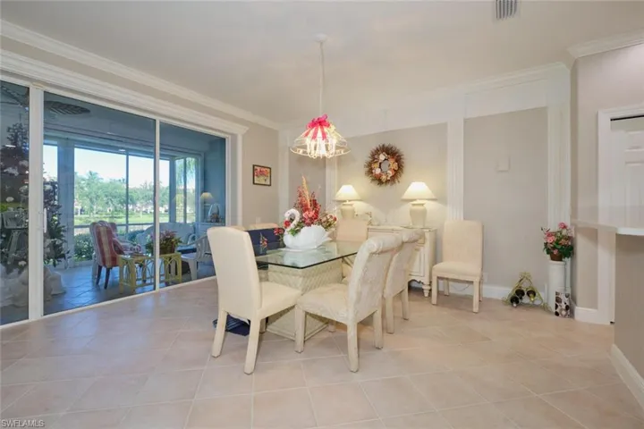 Tiled dining room featuring a notable chandelier and ornamental molding