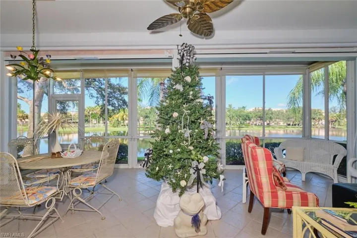 Sunroom with a wealth of natural light, ceiling fan, and a water view