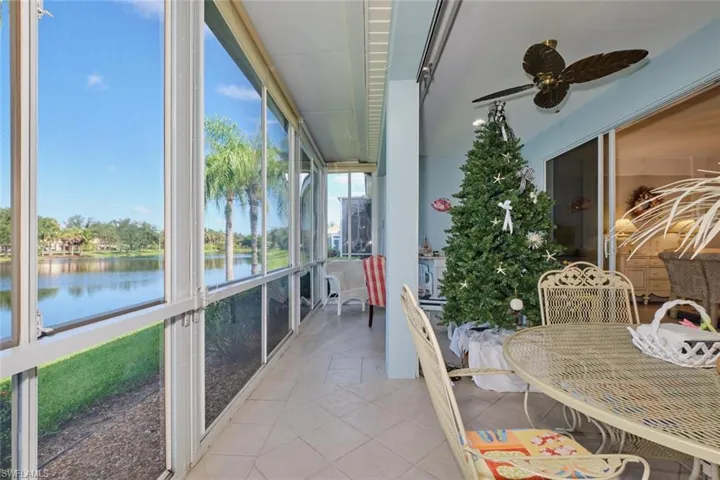 Sunroom / solarium featuring plenty of natural light, ceiling fan, and a water view